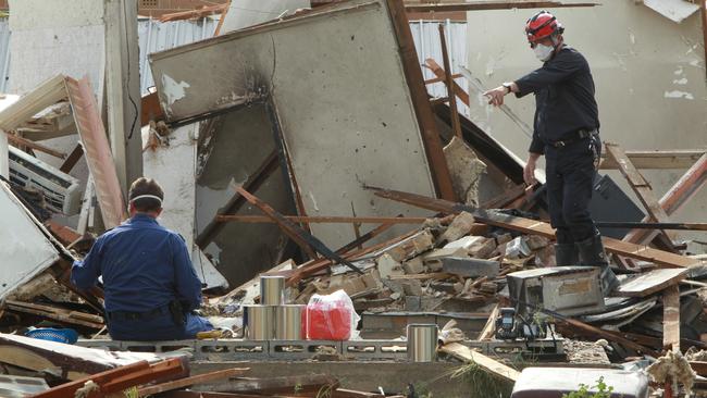 Investigators amid the rubble of the house which “shook the neighbourhood” when it exploded. Picture: News Corp.