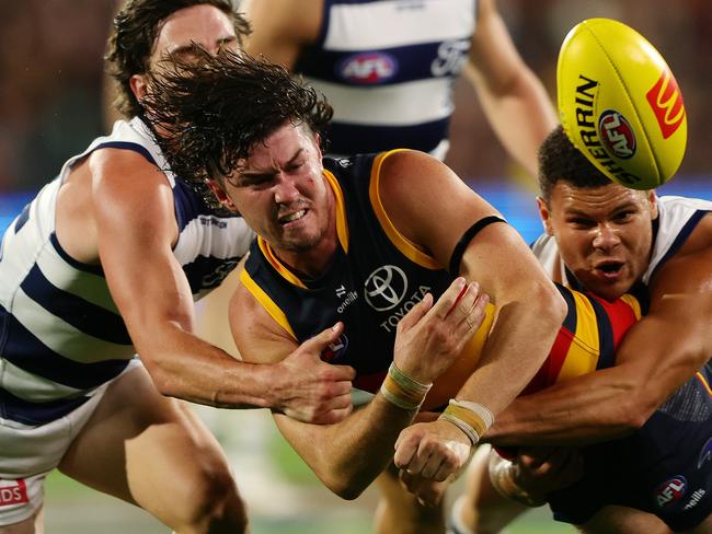 ADELAIDE, AUSTRALIA - MARCH 22: Ned McHenry of the Crows under pressure from Gryan Miers of the Cats and Brandan Parfitt of the Cats during the 2024 AFL Round 2 match between the Adelaide Crows and the Geelong Cats at Adelaide Oval on March 22, 2024 in Adelaide, Australia. (Photo by Sarah Reed/AFL Photos via Getty Images)