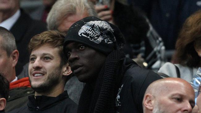 Liverpool's new man Mario Balotelli watches on at the Etihad with fellow recruit Adam Lallana.