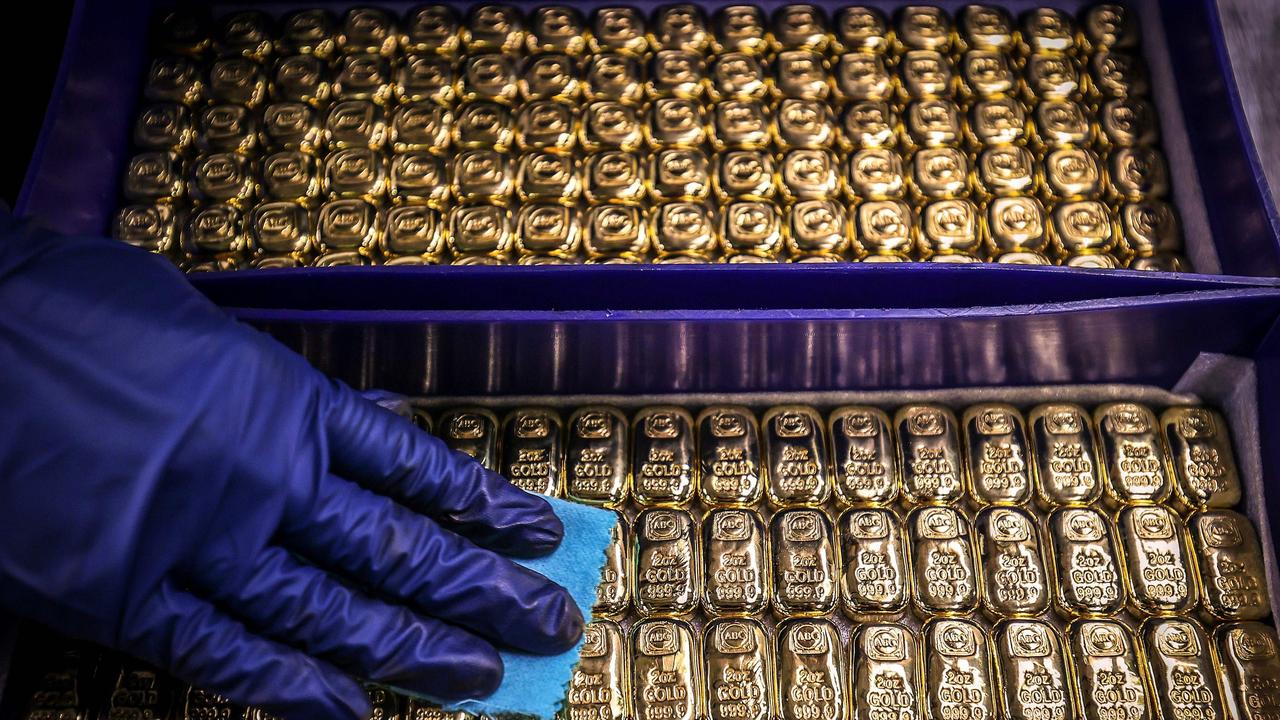 A worker polishes gold bullion bars at the ABC Refinery in Sydney. Picture: David Gray/ AFP.