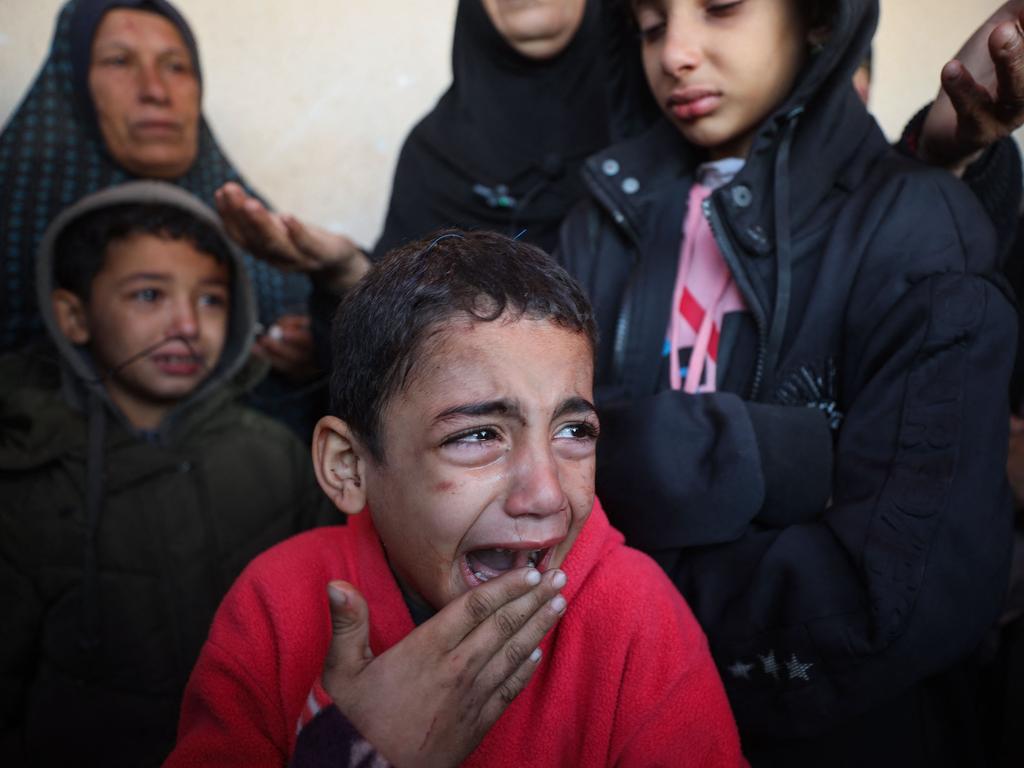 Palestinian children cry after their relatives, including infants, were killed in an Israeli airstrike on their shelter in Deir el-Balah in the central Gaza Strip on January 14.(Photo by AFP)