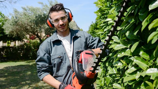 CAREERS: One side hustle is no longer enough to make ends meet, with a growing number of Australians requiring several income streams to pay their mortgage and put food on the table.  Young man gardener trimming hedge. Picture: iStock