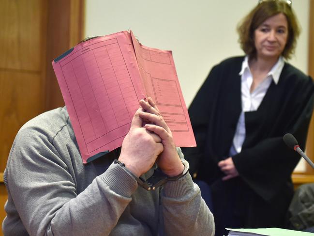 Hoegel hides his face behind a folder as he waits next to his lawyer Ulrike Baumann. Picture: Carmen Jaspersen/DPA/AFP