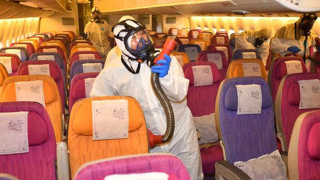 Thai Airways staff disinfect an aircraft in Bangkok in a bid to stop the coronavirus spread in Thailand. Picture: AFP