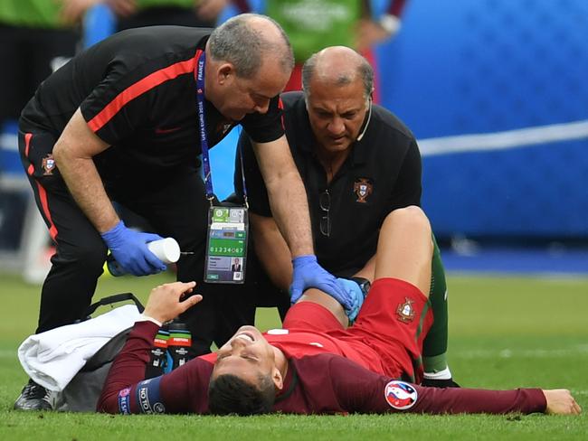 Ronaldo grimaces in agony as medical staff attend to his injury.