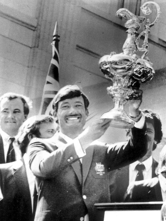 John Bertrand hoisting the America’s Cup trophy aloft.