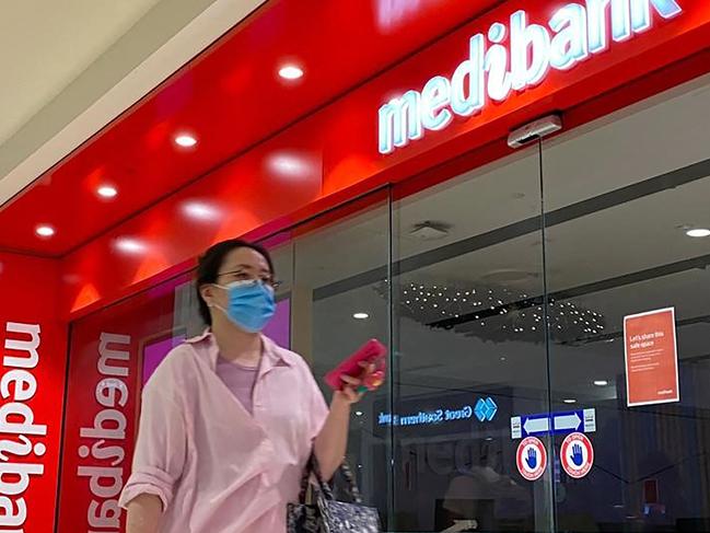 People walk past a shop front for Australia's largest health insurance company Medibank, in Sydney on November 11, 2022. - Russian hackers carried out a cyberattack on Medibank that breached the data of 9.7 million people, including the country's prime minister, police said 11 November. (Photo by Muhammad FAROOQ / AFP)