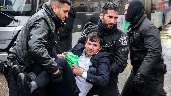 Israeli policemen try to forcibly remove Ultra-orthodox Jewish protesters assembling for a protest against their conscription into the Israeli armed forces. Picture: AFP