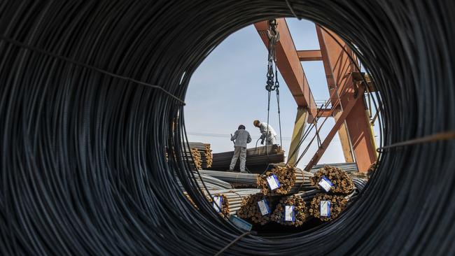 Workers prepare to lift a bundle of steel reinforcing bar with a gantry crane at a metal stock yard in Shanghai, China. Picture: Qilai Shen/Bloomberg