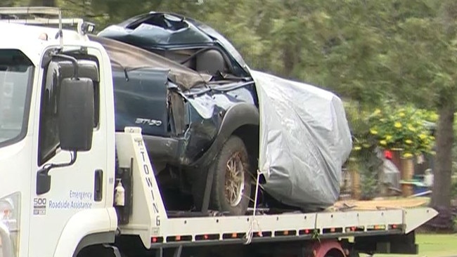 The mangled ute being removed from the scene.