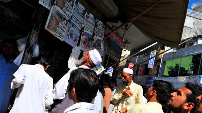 Local residents in Abbottabad crowd around a news stand just a few kilometres from Osama bin Laden's compound. Picture: Rick Westhead