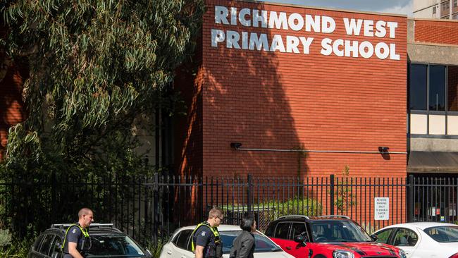 A man is led away in handcuffs in the school’s carpark. Picture: Jason Edwards