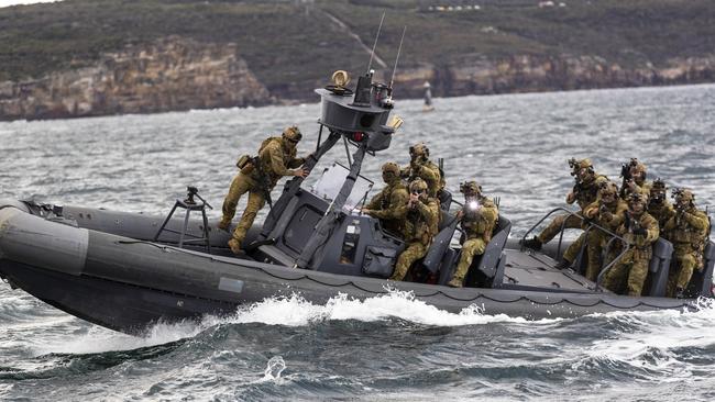 Australian Army 2nd Commando Regiment prepare to board a Sydney ferry from an Army rigid-hulled boat.