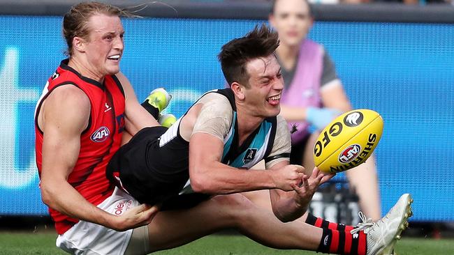 Port Adelaide’s everywhere man: Zak Butters handpasses the ball despite the attention from Mason Redman.