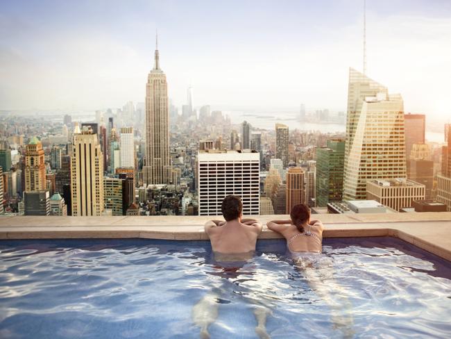 ESCAPE: TIGHT TRAVEL, Angus Kidman - 3MAR19-  Couple relaxing in swimming pool on hotel rooftop Picture: iStock