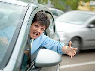 Young Woman Driver Yelling and Shaking her Wrist out Car Window. Picture: AlexanderNovikov