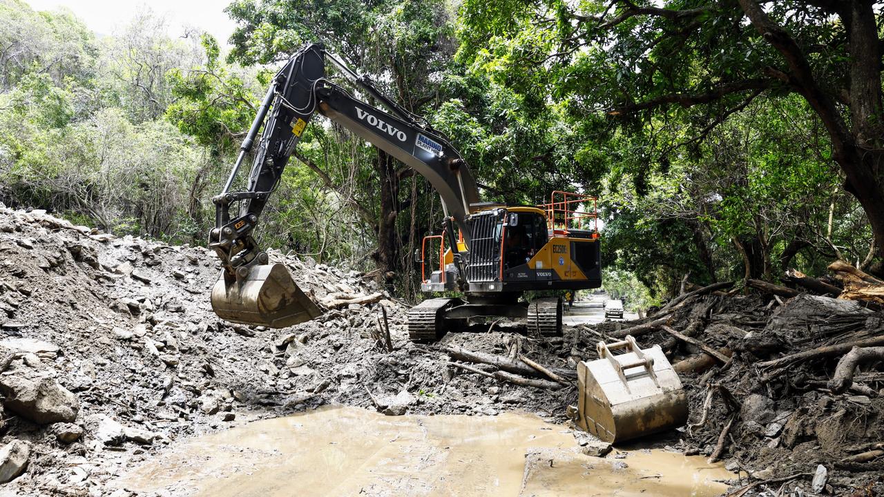 An excavator clears debris from a huge landslide covering the Captain Cook Highway at Ellis Beach. Debris including mud, rocks and tree vegetation completely cutting the highway. Picture: Brendan Radke