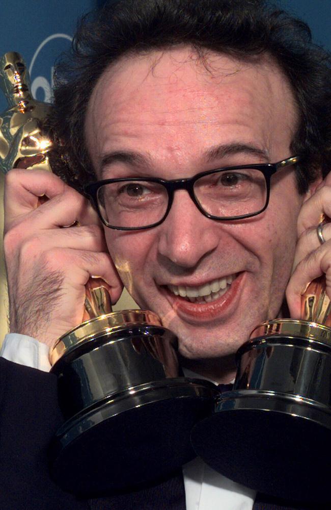 Roberto Benigni holds the Oscars he won for best foreign film and best actor for <i>Life Is Beautiful.</i>