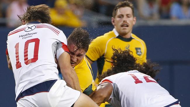 United States' Alan Macginty, left, and Thretton Palamo, right, defend against Australia's Sean McMahon, center, during the first half of an international rugby test match at Soldier Field, Saturday, Sept. 5, 2015, in Chicago. (AP Photo/Kamil Krzaczynski)