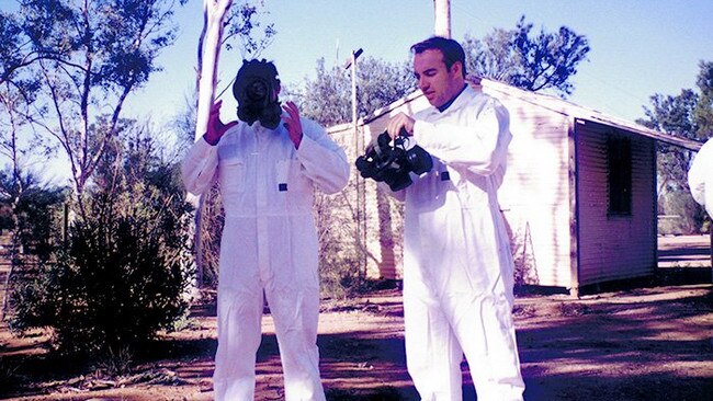 On right, AFP Detective Superintendent Blaise O'Shaughnessy puts on a protective mask before undertaking a search at Banjawarn Station. Picture: Australian Federal Police