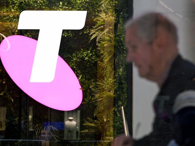 A man walks past the office of Australian telecoms company Telstra in the central business district of Sydney on May 21, 2024. Leading Australian telecoms company Telstra said May 21 it would slash up to 2,800 jobs, shedding nine percent of its workforce as it keeps pace with "rapid advances in technology". (Photo by Saeed KHAN / AFP)
