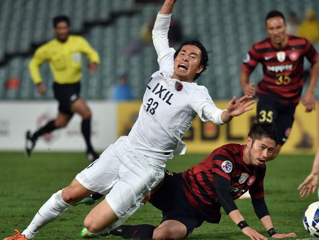 Mu Kanazaki (L) of Japan's Kashima Antlers fights for the ball with Yusuke Tanaka (C) of Australia's Western Sydney Wanderers during their AFC Champions League football match in Sydney on April 21, 2015. AFP PHOTO / Saeed KHAN -- IMAGE RESTRICTED TO EDITORIAL USE - STRICTLY NO COMMERCIAL USE