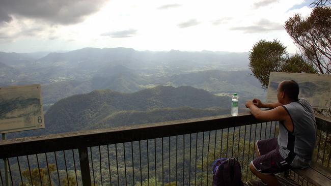 Bush Walker looking towards Queensland from the summit lookout of Mt Warning in Northern NSW - travel tourism nsw scenic mountain range