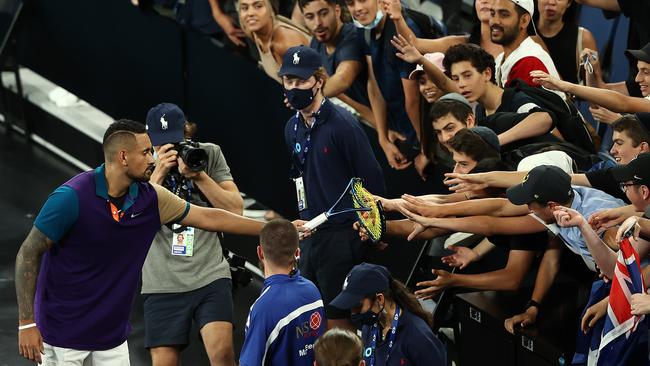 Nick Kyrgios gives his broken racquet to fans after winning his second round match against Frenchman Ugo Humbert