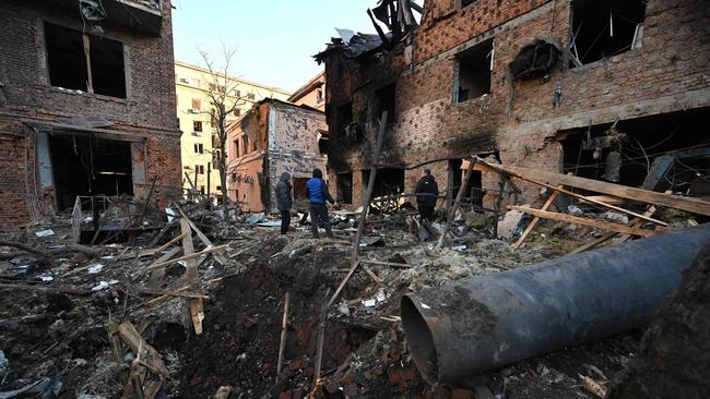 Residents inspect damage after the overnight Russian drones attack on Kharkiv on Sunday. Picture: AFP