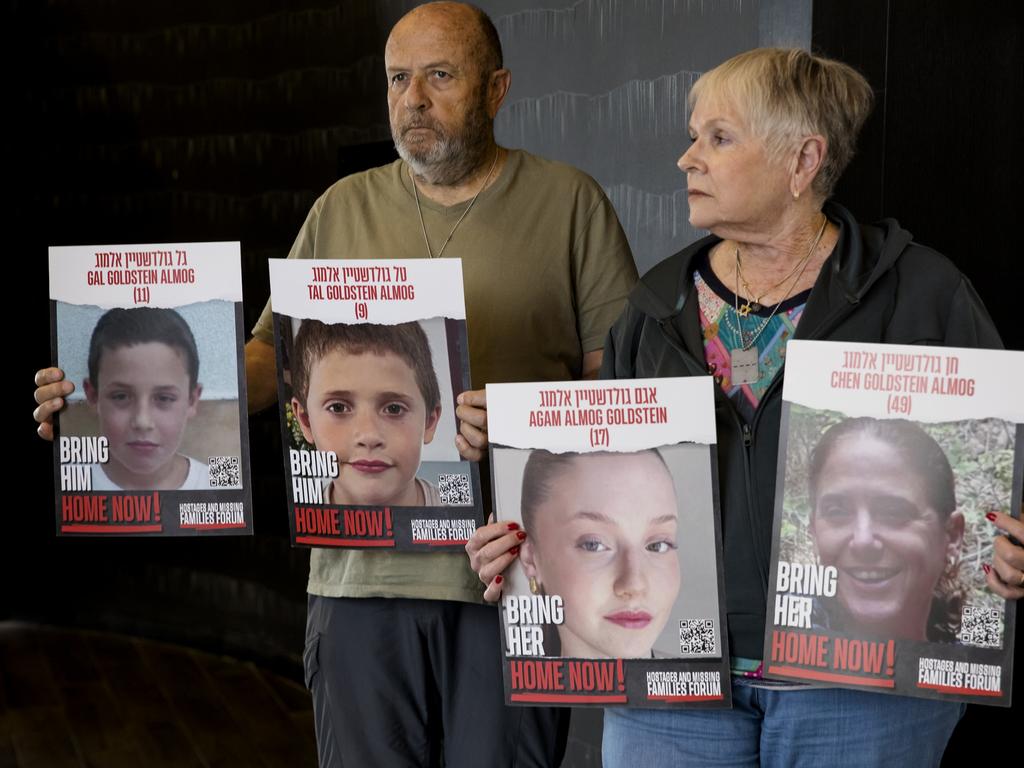 David and Varda Goldstein holding-up photos of their three grandchildren, Gal, Tal and Agam, and their mother, Chen. Picture: Getty Images