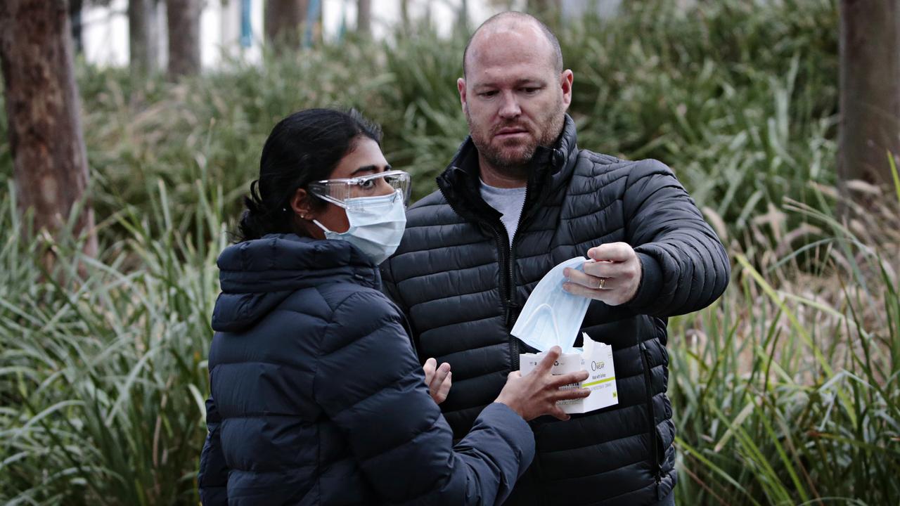 Health staff giving out masks to people at Sydney’s mass vaccination hub in Sydney Olympic Park. Picture: Adam Yip/NCA NewsWire