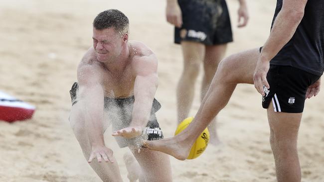 Peter Ladhams smothers the footy during a beach drill on Port’s pre-season camp in Maroochydore. Picture: Sarah Reed