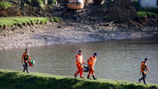 SES volunteers on the edge of the dam at Echunga after a night of reducing the water levels in the dam to stop potential flooding. Picture: Kelly Barnes