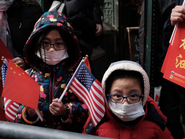 NEW YORK, NEW YORK - FEBRUARY 09: Children wearing surgical masks watch the annual Lunar New Year Parade in Manhattan's Chinatown on February 09, 2020 in New York City. This years parade comes as China is fighting the growing coronavirus which has killed hundreds and impacted global trade and tourism around the world. As the virus originated in China before quickly spreading, Asian communities have been especially concerned about the virus appearing in their communities.   Spencer Platt/Getty Images/AFP == FOR NEWSPAPERS, INTERNET, TELCOS & TELEVISION USE ONLY ==