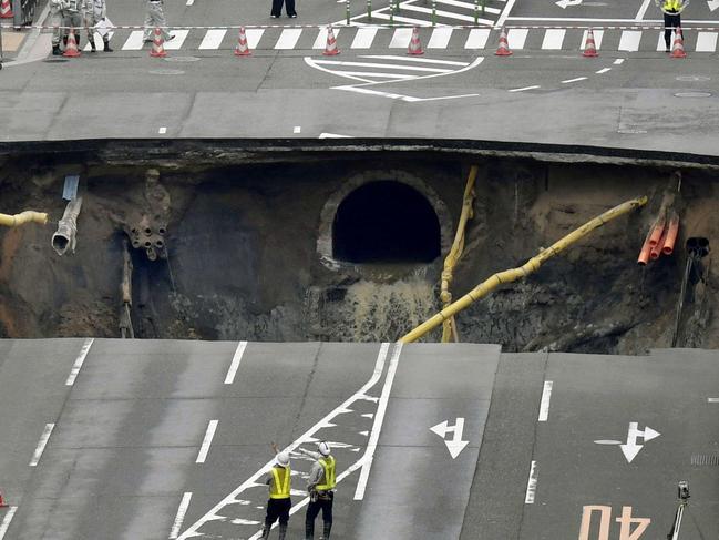 A massive shinkhole is created in the middle of the business district in Fukuoka, southern Japan Tuesday, Nov. 8, 2016. Parts of a main street have collapsed in the city, creating a huge sinkhole and cutting off power, water and gas supplies to parts of the city. Authorities said no injuries were reported from Tuesday's pre-sunrise collapse in downtown Fukuoka. (Sadayuki Goto/Kyodo News via AP)