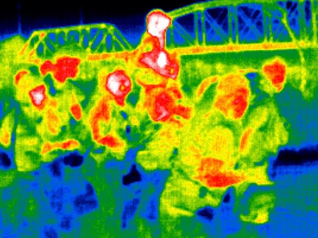 As seen with a thermal camera, a family wades through the strong current of the Rio Grande while crossing from Mexico into the USA in Eagle Pass, Texas. Picture: John Moore/Getty Images