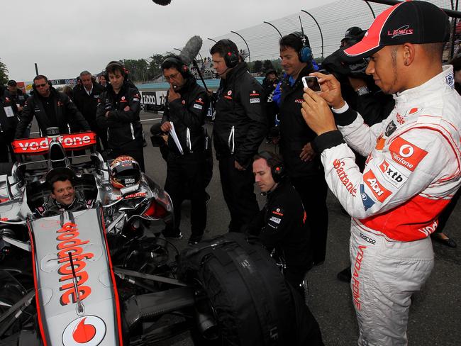 Lewis Hamilton of England (R) takes pictures of Nascar driver Tony Stewart as he sits in the Vodafone McLaren Mercedes MP4-23 during the Mobil 1 Car Swap at Watkins Glen International on June 14, 2011. Picture: Getty Images for Mobil 1/AFP