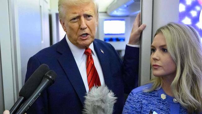 US President Donald Trump, watched by White House Press Secretary Karoline Leavitt, speaks to reporters while in flight on Air Force One en route Joint Base Andrews, on January 27, 2025. (Photo by Mandel NGAN / AFP)