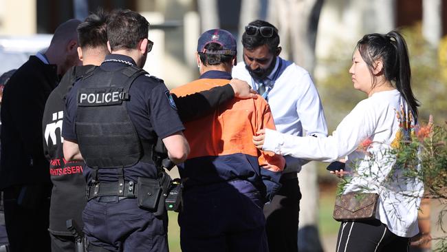 A man is comforted outside the home. Picture: Nigel Hallett