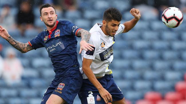 Newcastle Jets striker Roy O’Donovan (left) and Central Coast Mariners defender Jonathan Aspropotamitis compete for the ball. Picture: Getty Images