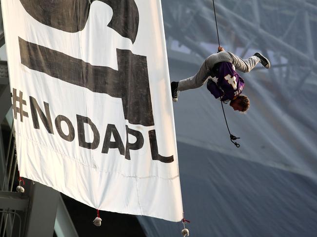 MINNEAPOLIS, MN - JANUARY 1: A protestor wearing a Brett Farve jersey dangles upside down above Minnesota Vikings and Chicago Bears football game on January 1, 2017 at US Bank Stadium in Minneapolis, Minnesota. Two protesters hung a banner in opposition to the Dakota Access Pipeline from the rafters of the stadium in the second quarter of the game. Adam Bettcher/Getty Images/AFP == FOR NEWSPAPERS, INTERNET, TELCOS & TELEVISION USE ONLY ==