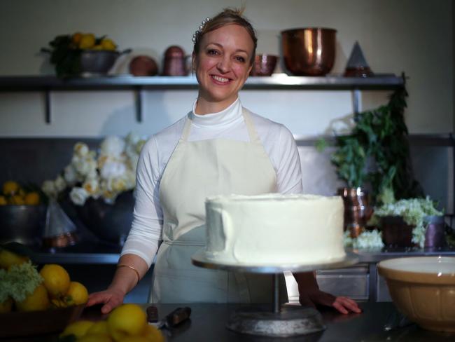 Claire Ptak poses for a portrait with a tier of the wedding cake. Picture: AFP