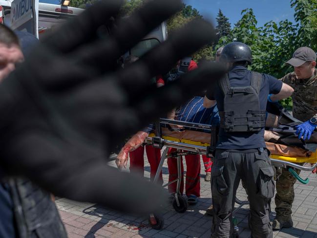 A Ukrainian man killed at the main square of Bakhmut is carried by soldiers and emergency services after a bombardment in Bakhmut, Eastern Ukraine. Picture: AFP