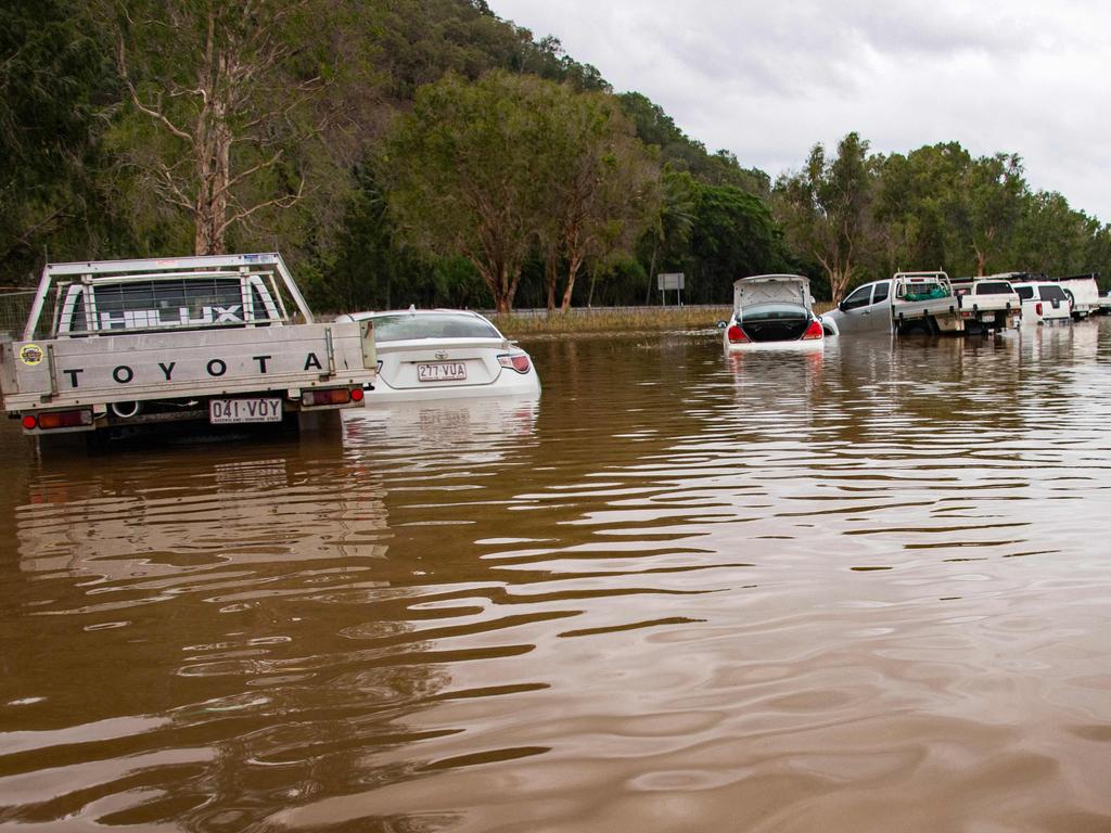 Cars stranded in floodwaters at Cairns Airport. Picture: Brian Cassey/AFP