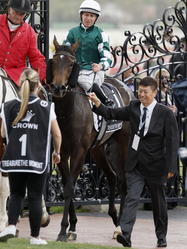 Yulong Stud owner Yuesheng Zhang leads Oaks winner Treasurethe Moment back to scale at Flemington on Thursday. Picture: Michael Klein