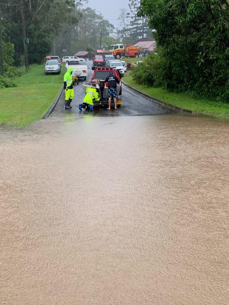 Friends helping out neighbours during flooding in Urunga on Wednesday morning, March 30, 2022.