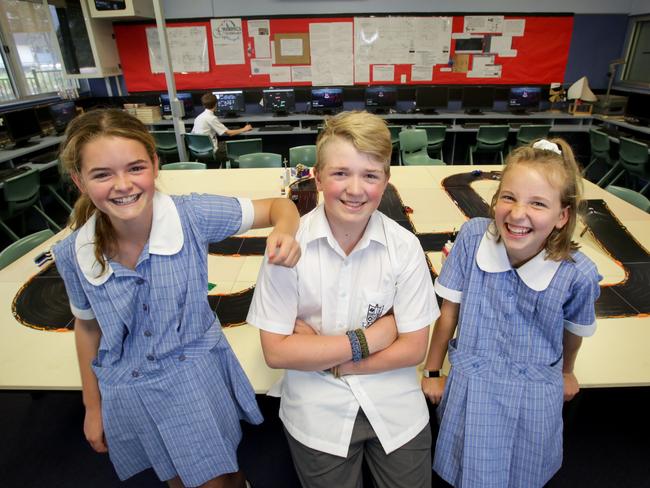 Pennant Hills High School students Emma Davidson, 13, Scott Romanis, 13, and Annie Bennett, 12, using a racing car course that they program with code. Picture: Liam Driver