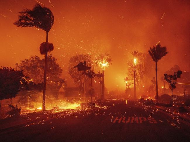 The Palisades Fire ravages a neighborhood amid high winds in the Pacific Palisades neighborhood of Los Angeles, Tuesday, Jan. 7, 2025. (AP Photo/Ethan Swope)