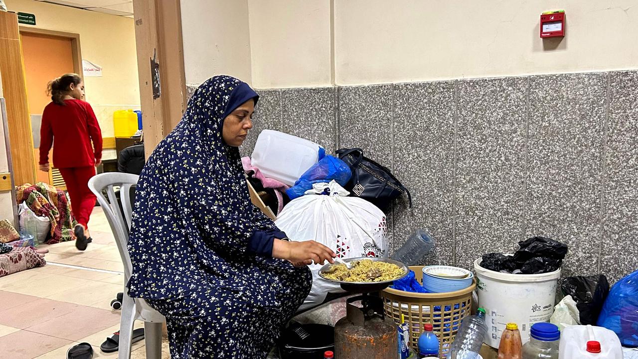 An internally displaced woman cooks while camping at Al-Shifa hospital in Gaza City. Picture: AFP