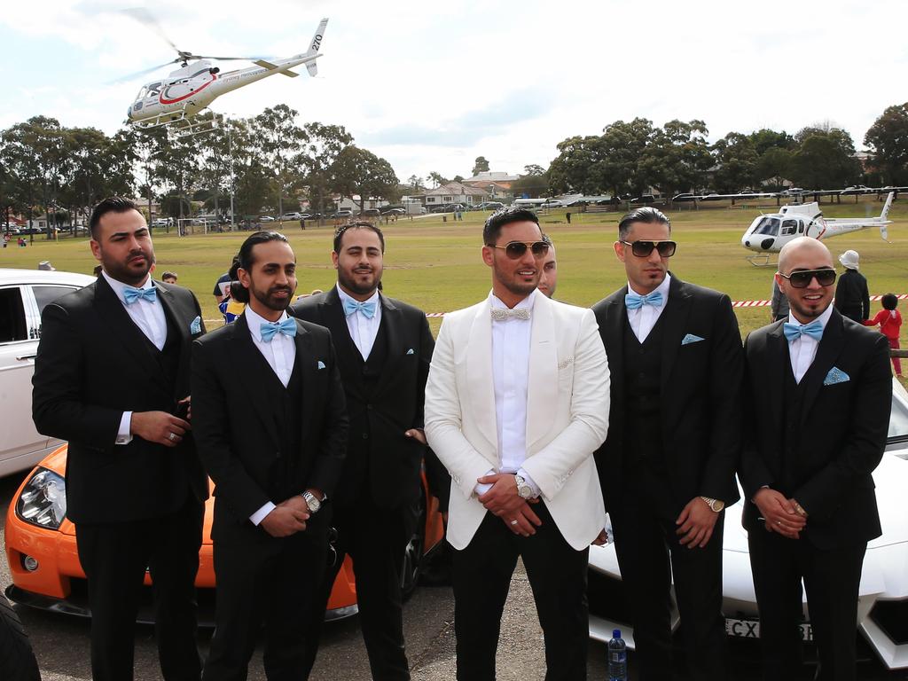 Salim Mehajer poses with his groomsmen, with the luxury cars and helicopter in the background. Picture: Toby Zerna